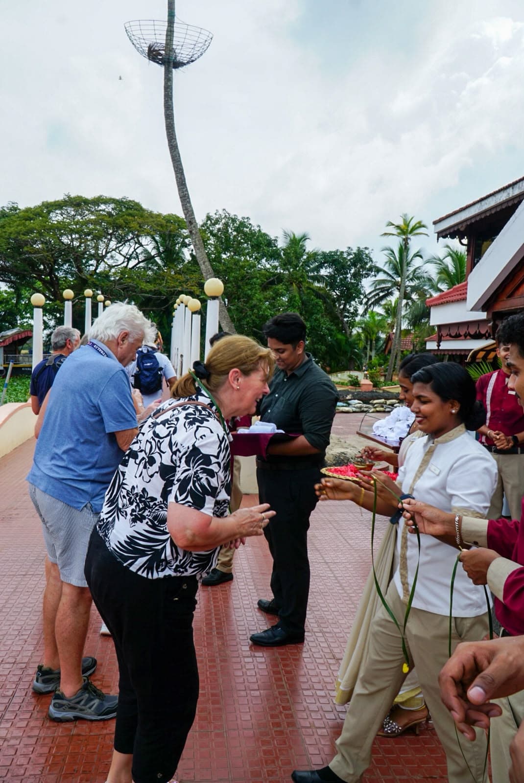 Guests receiving a traditional welcome from hosts holding brass trays on arrival.